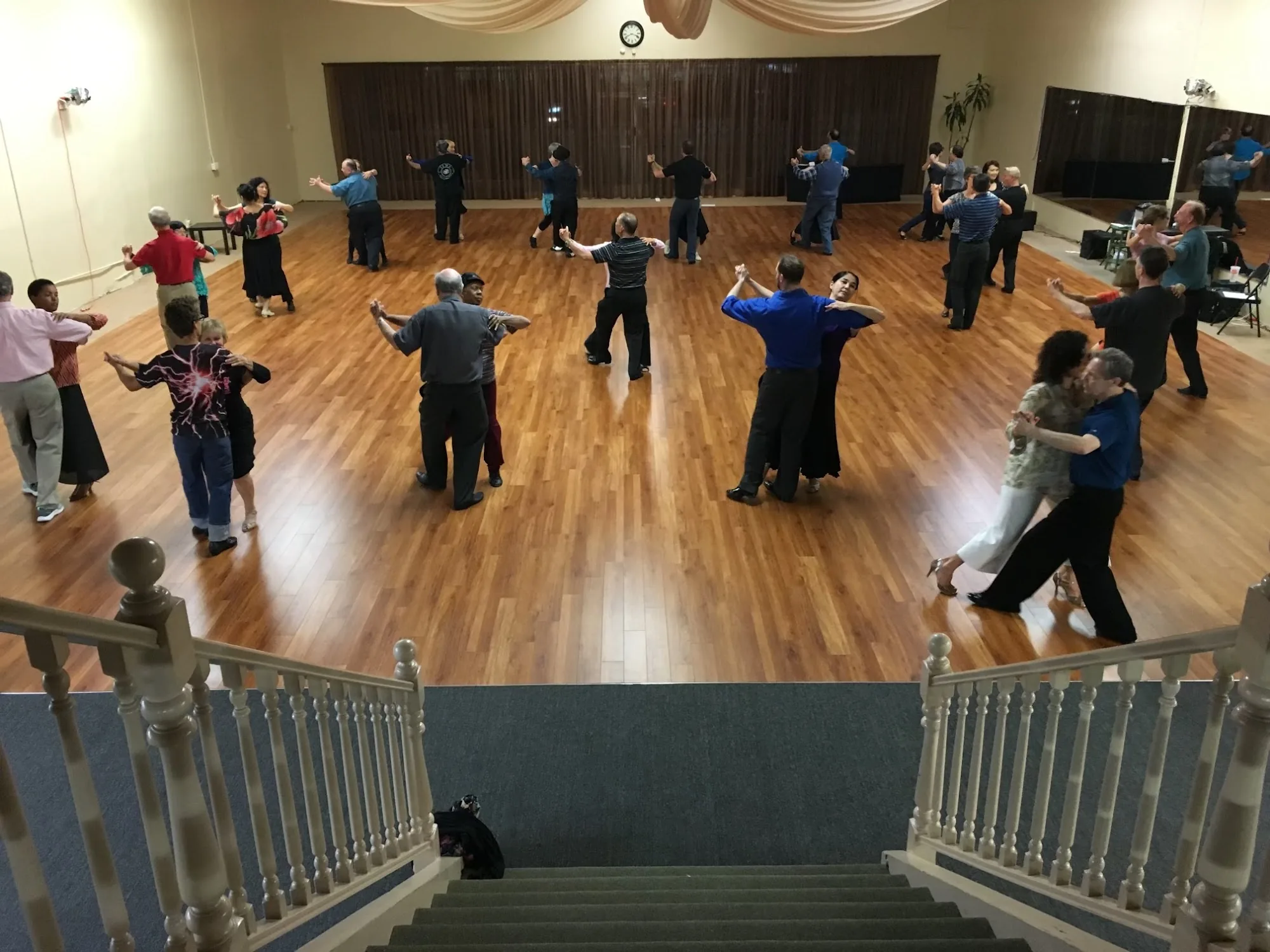 Ballroom social dance with multiple couples on wooden floor at Hollywood Academy of Dance Los Angeles