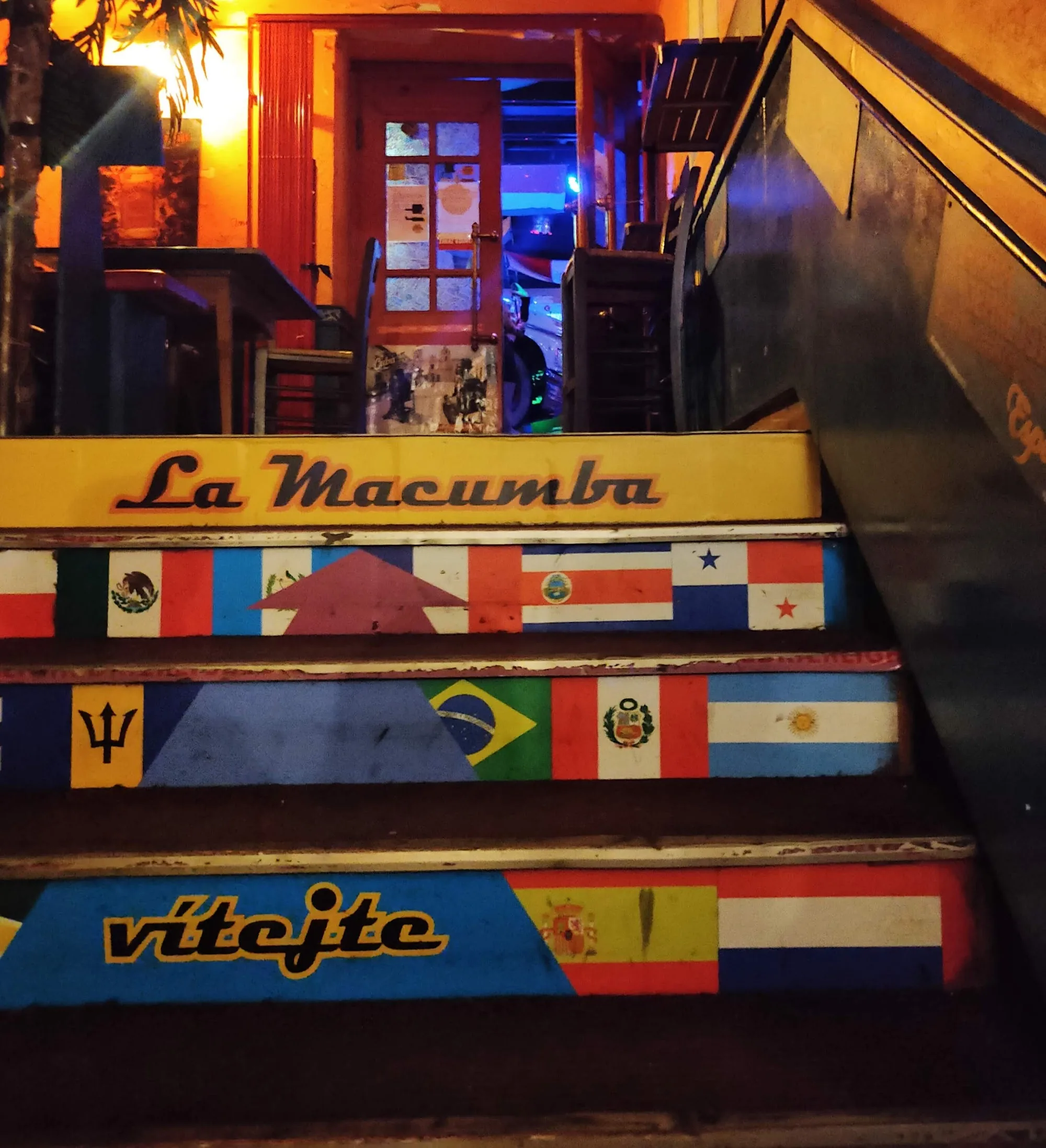 Neon-lit branded staircase at La Macumba with Latin American country flags decorating the walls