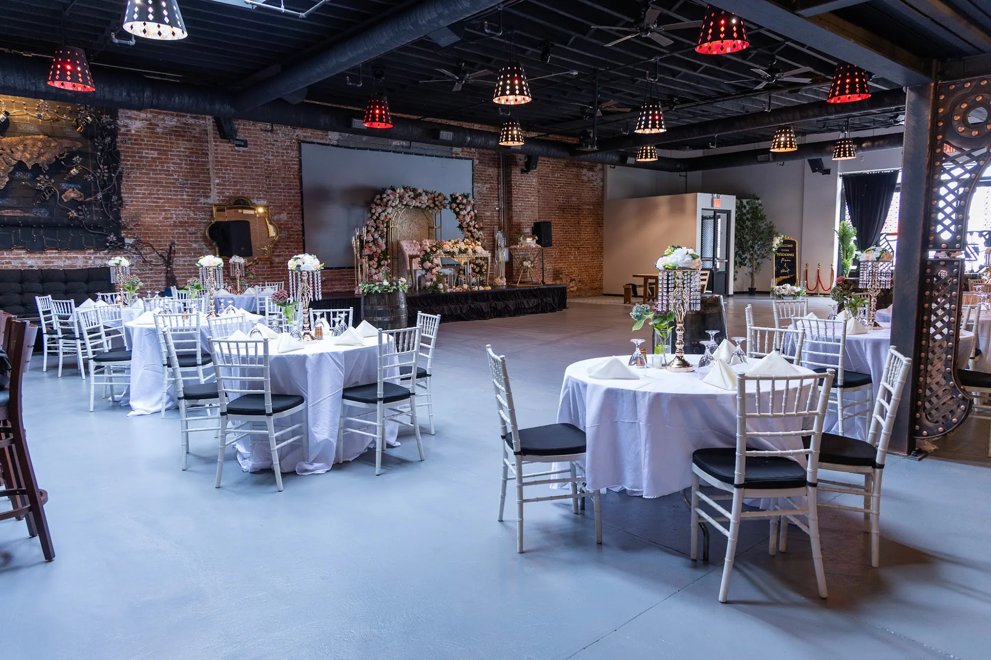 Industrial brick interior with red lampshades at Atolye Venue & Bar in New York