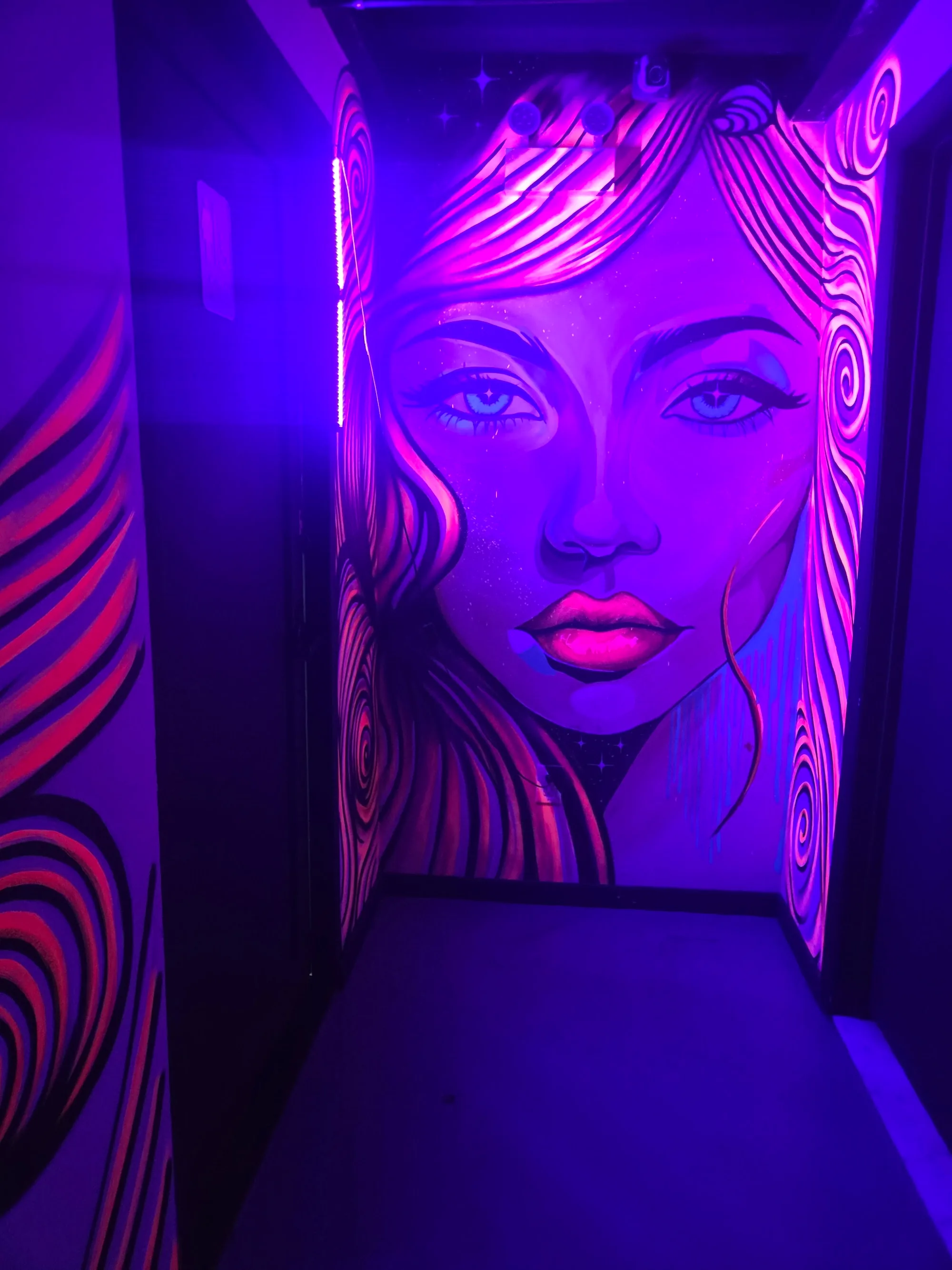 Neon UV-lit mural corridor at Atolye Venue & Bar in New York