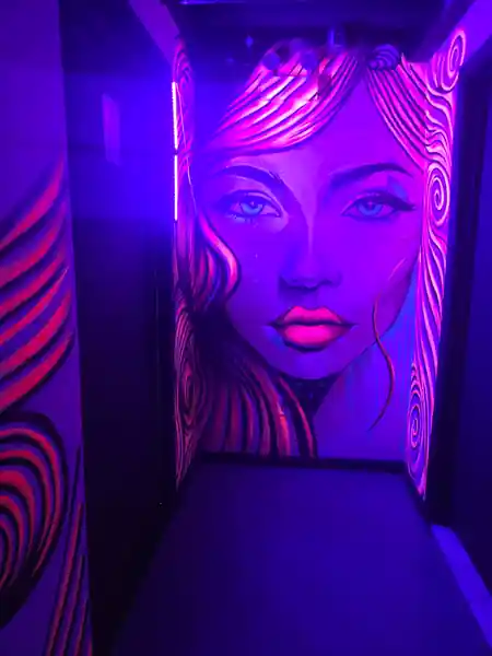 Neon UV-lit mural corridor at Atolye Venue & Bar in New York — salsa, bachata venue in New York