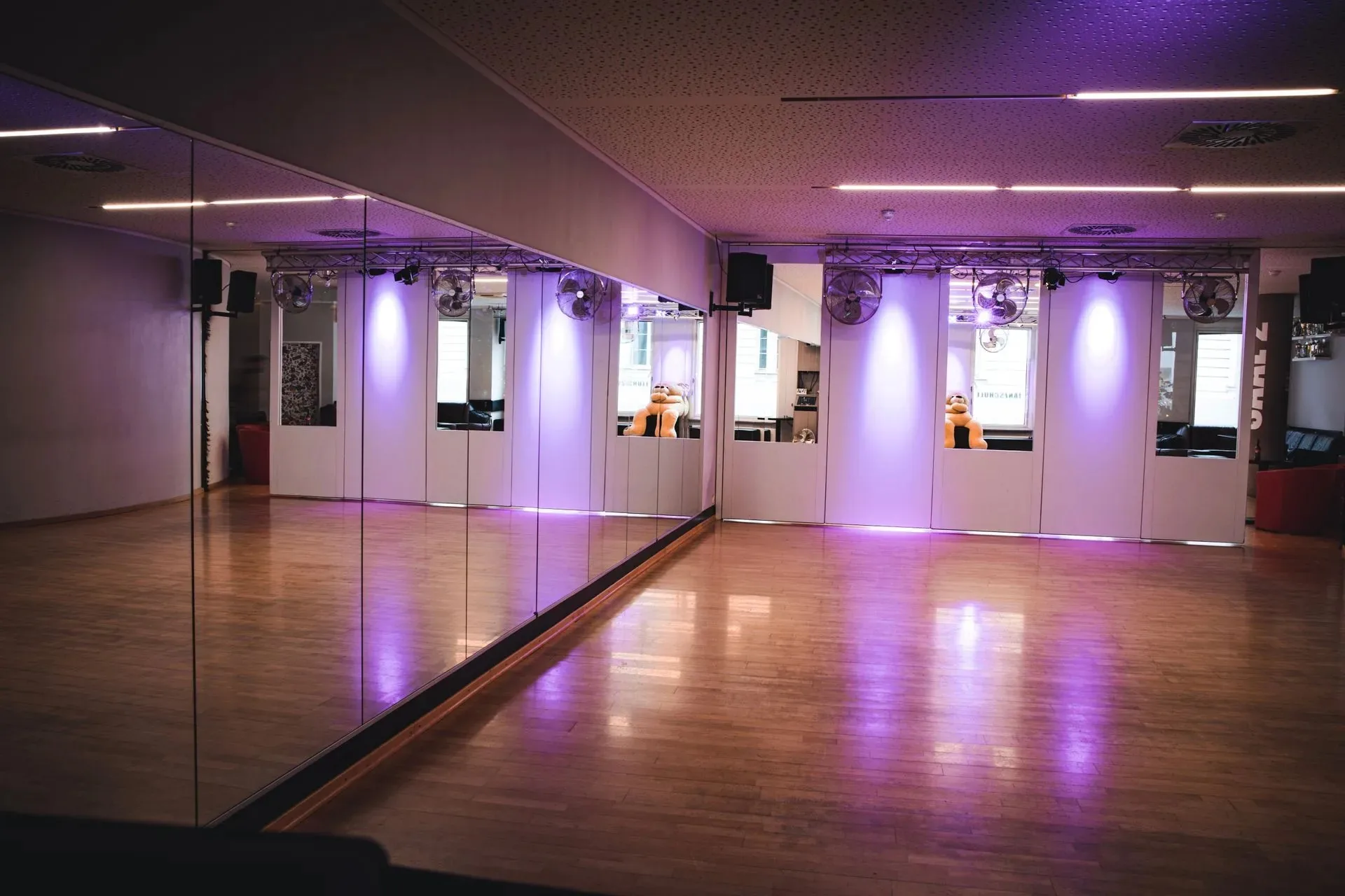Mirrored dance studio with wooden floor and purple lighting at Kult Tanzstudio in Munich