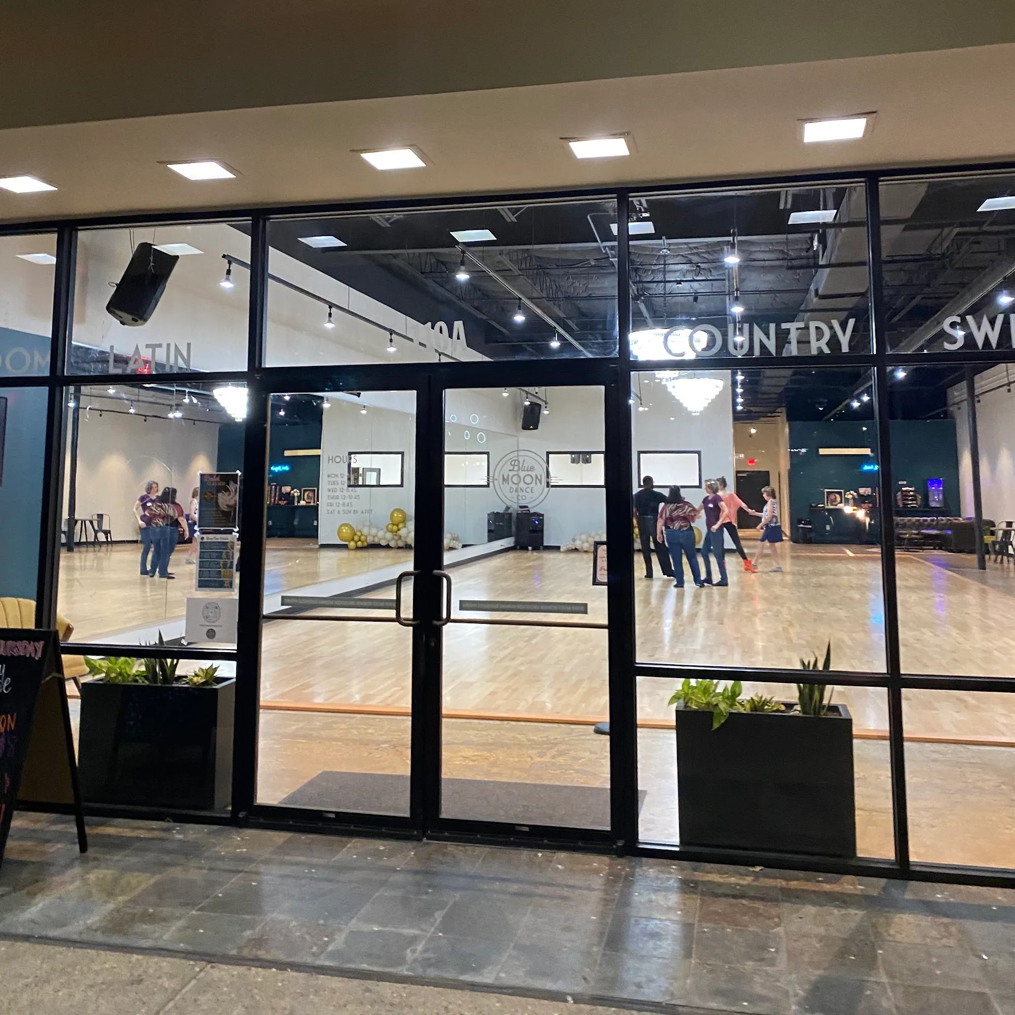 Branded glass storefront entrance of Blue Moon Dance Co. dance studio in Austin