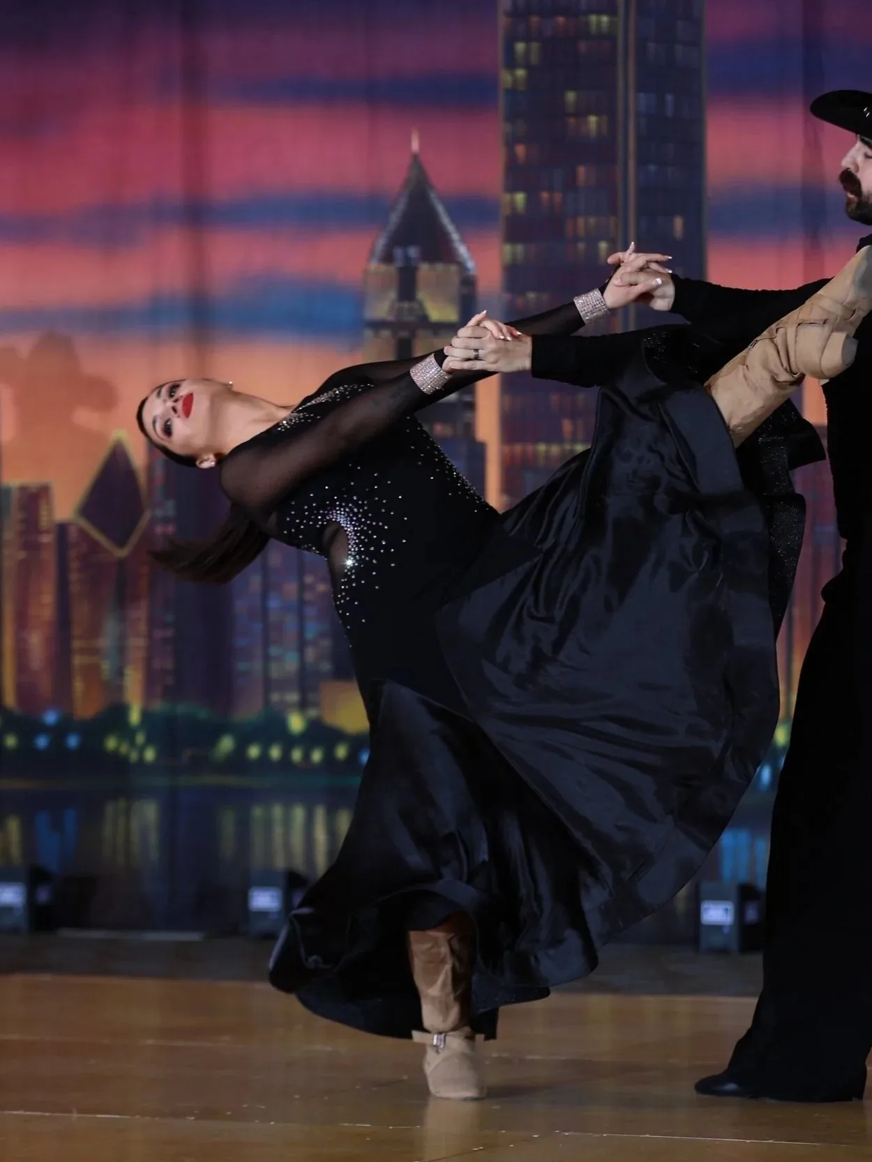Ballroom couple performing an elegant partner routine at Blue Moon Dance Co., Austin