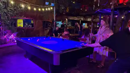 Guests playing pool under neon lights inside Hatch Bar in Bali — salsa, bachata venue in Bali
