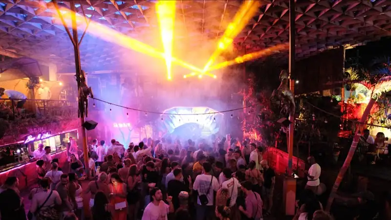 Packed dance floor with hundreds of dancers under colourful stage lighting at Hatch Bar, Bali — salsa, bachata venue in Bali