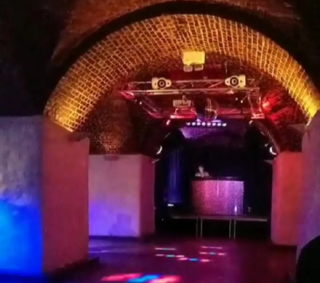 ME Nightclub dance floor with DJ booth and dramatic brick arch lighting in Trondheim Norway