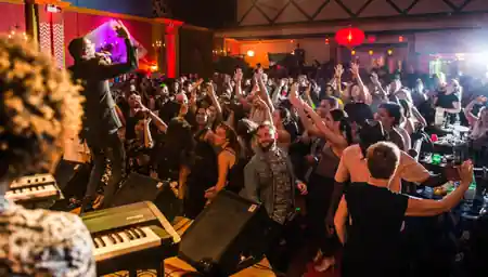 Live music night at Lula Lounge in Toronto, packed crowd enjoying a performance with the stage and colorful venue interior visible — salsa, bachata venue in Toronto