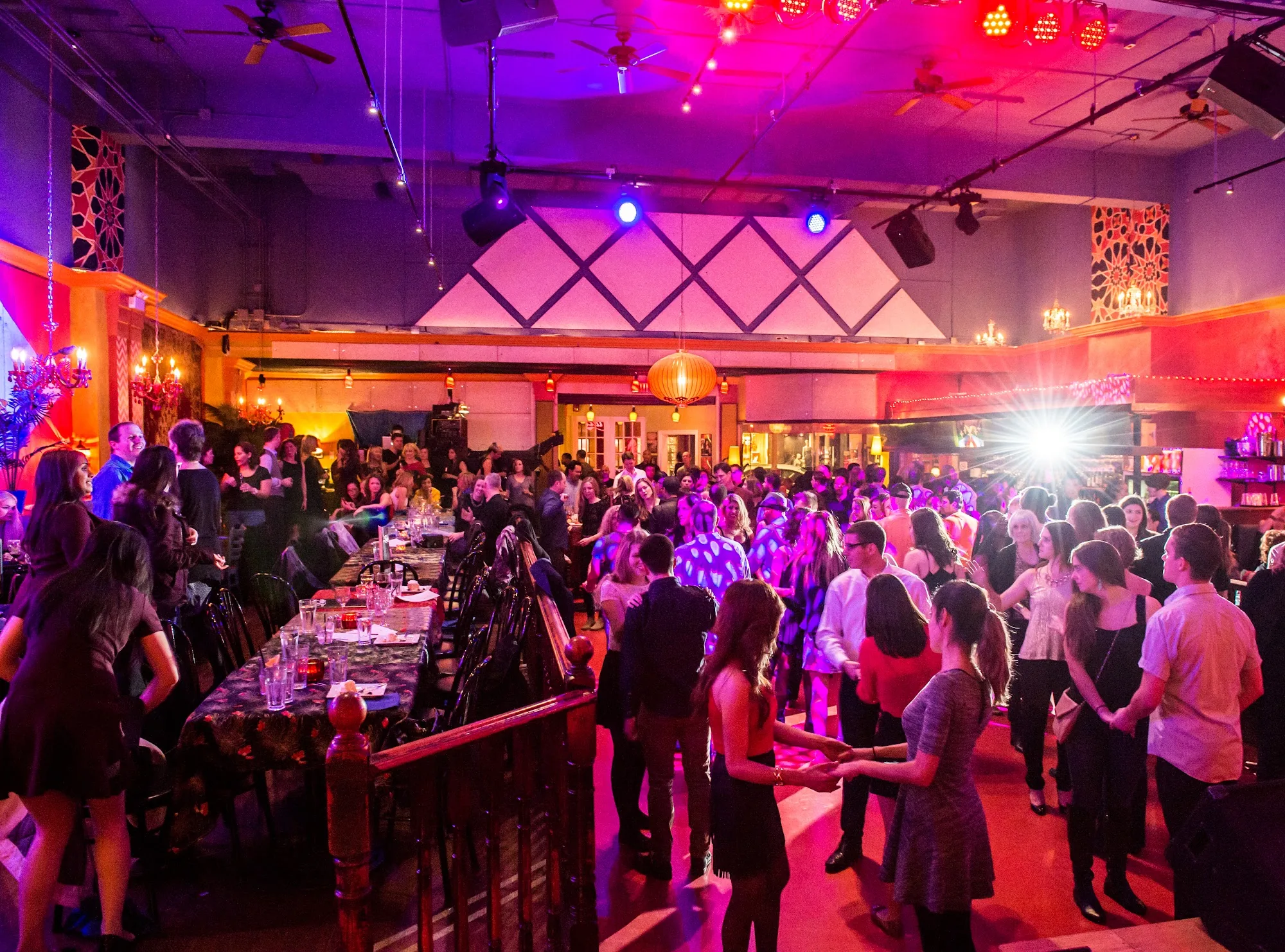Crowded dance floor with colorful lights and live stage at Lula Lounge Toronto