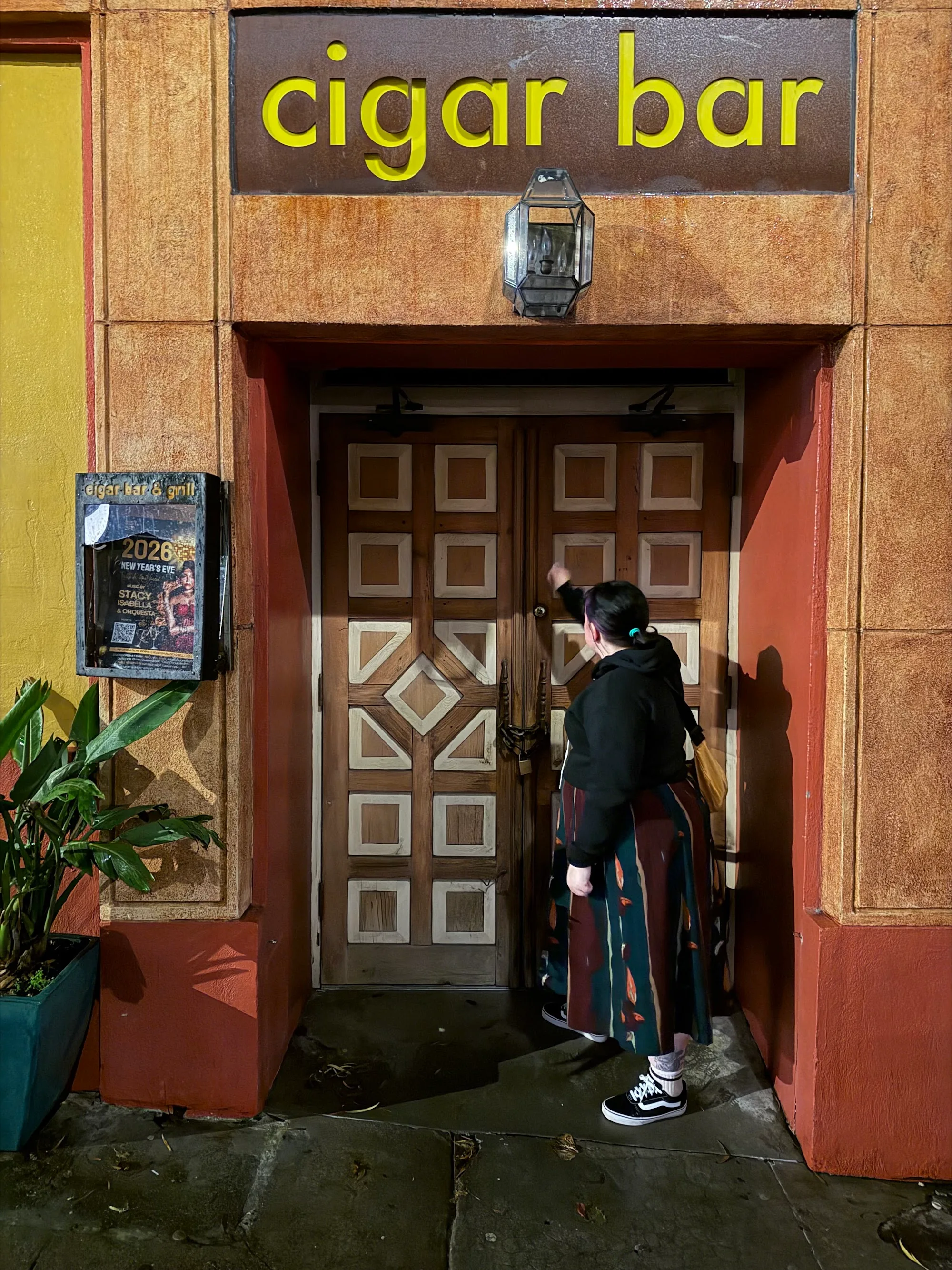 Patron entering Cigar Bar & Grill San Francisco through the branded wooden doors