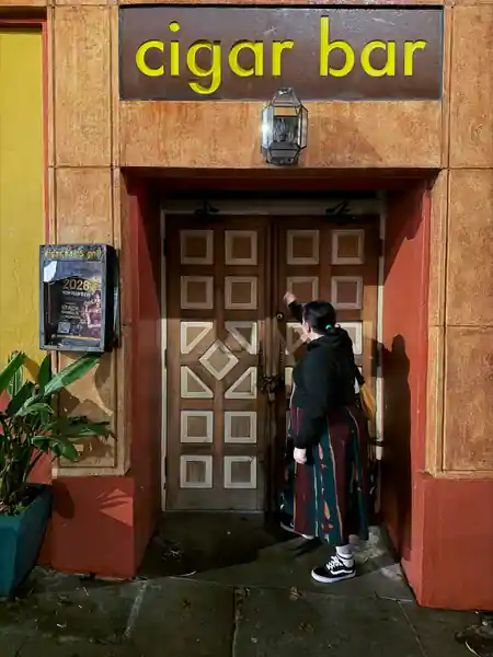 Patron entering Cigar Bar & Grill San Francisco through the branded wooden doors — salsa, bachata venue in San Francisco