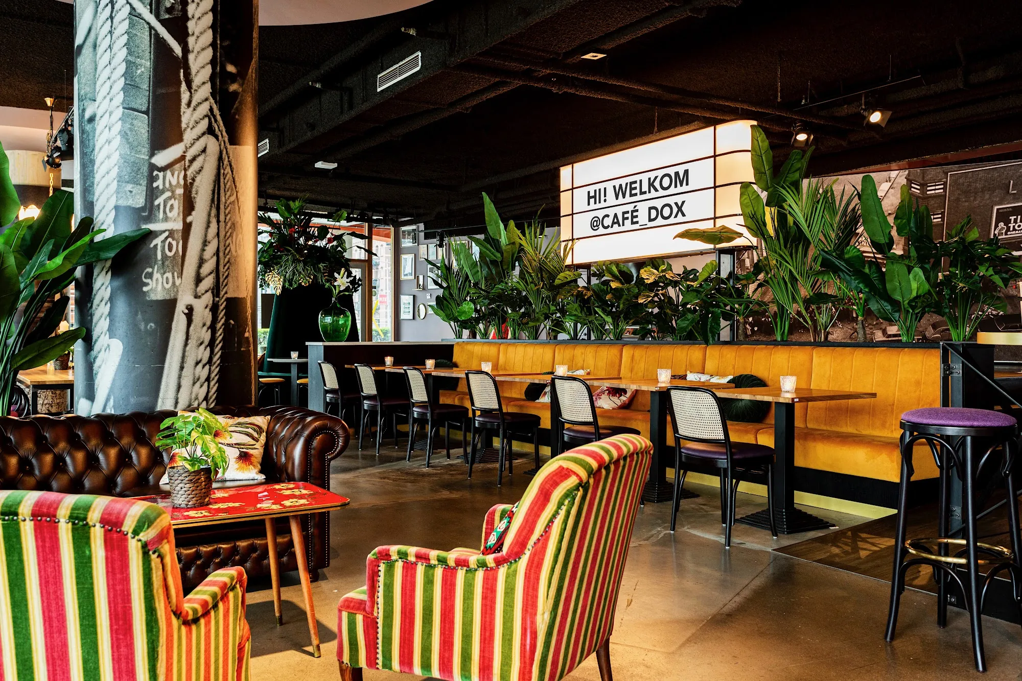 Café Dox interior with tropical plants and welcome sign in Rotterdam Netherlands