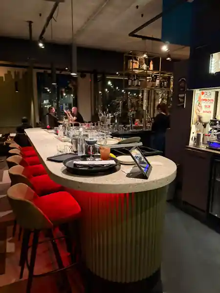 Bar interior at Cancún Amsterdam with salsa and bachata event poster on wall