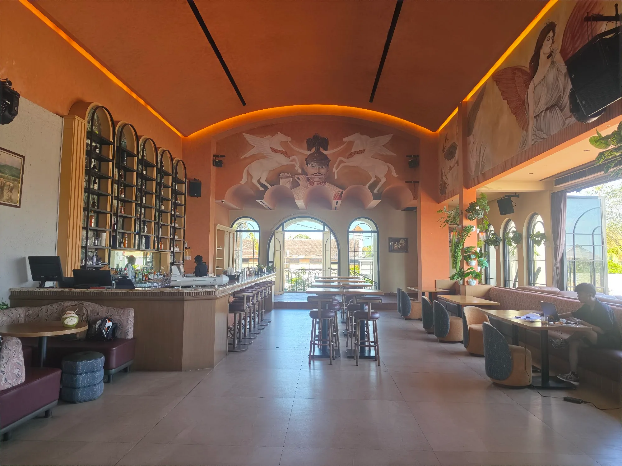 Bar with equestrian mural and vaulted ceiling at Amavi lounge in Canggu, Bali