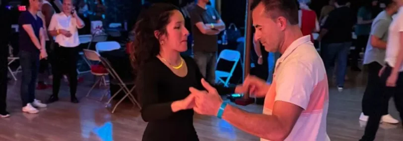 Couple dancing on the wooden floor at an Austin Inspired Movement social in Austin