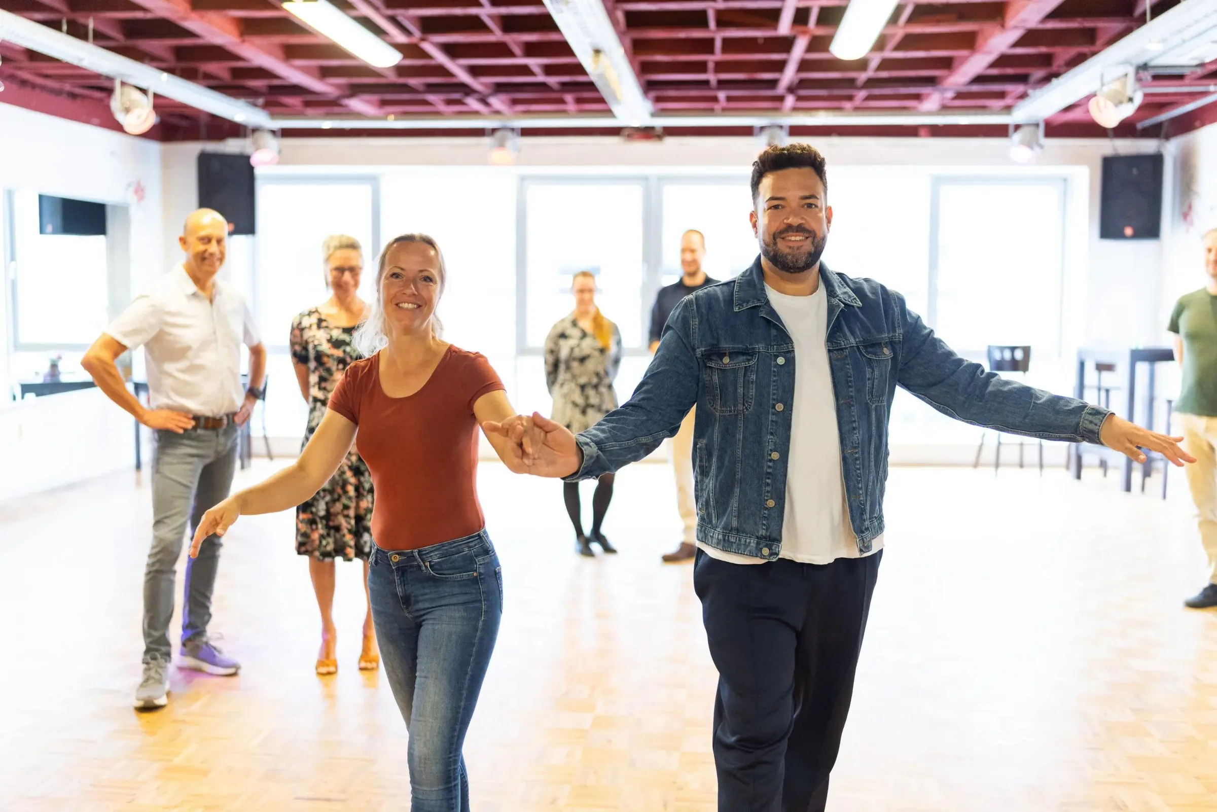Couple leading a partner dance in the bright SalsArena studio in Bremen