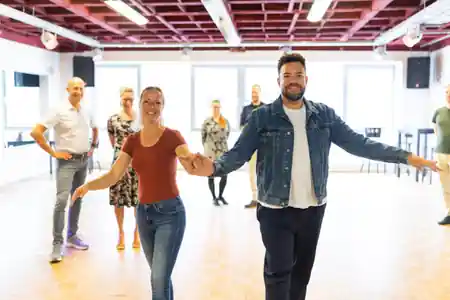 Couple leading a partner dance in the bright SalsArena studio in Bremen