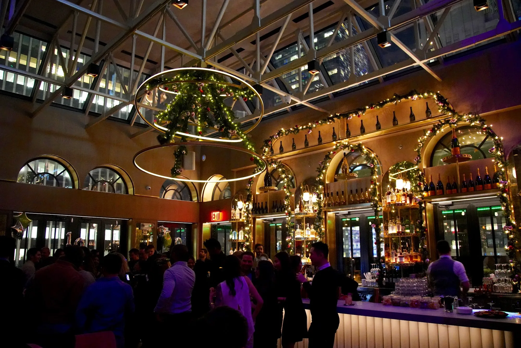 Festive party crowd at the Elsie Rooftop bar in New York with holiday lighting
