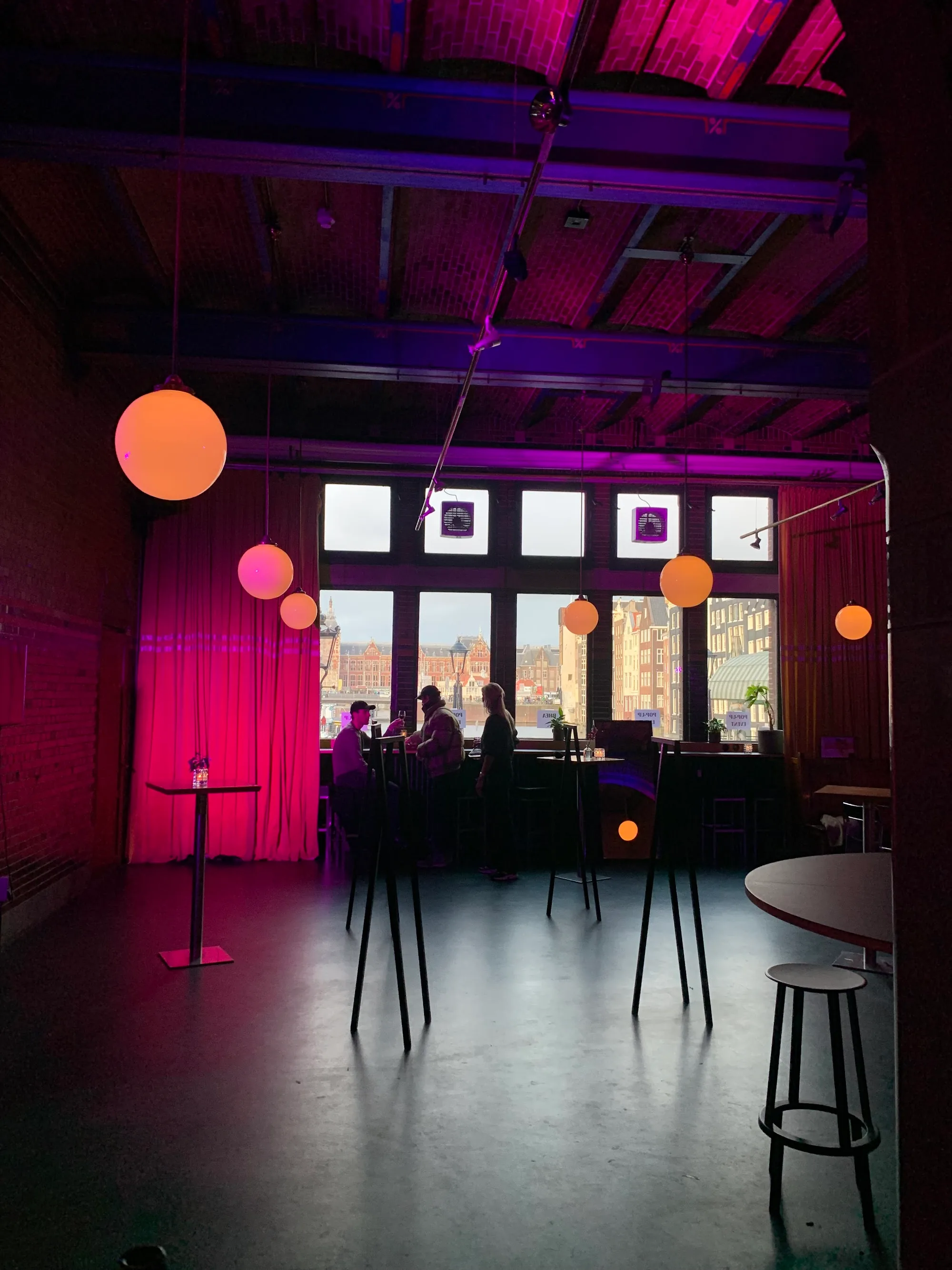 Purple-lit event space with panoramic city windows at The Brokers Bar Amsterdam