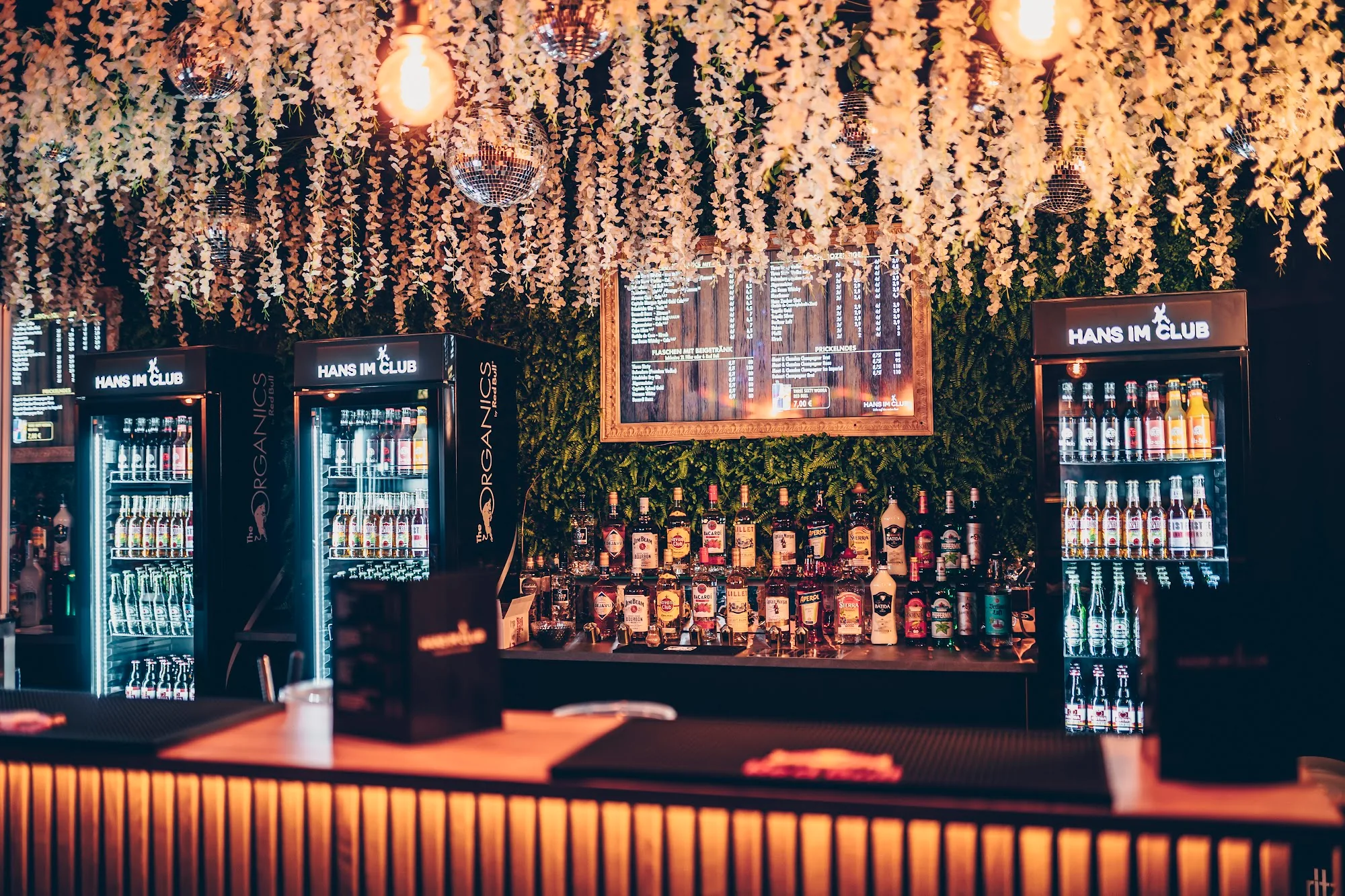 Hans im Club bar interior with flower canopy ceiling and branded fridges in Dresden
