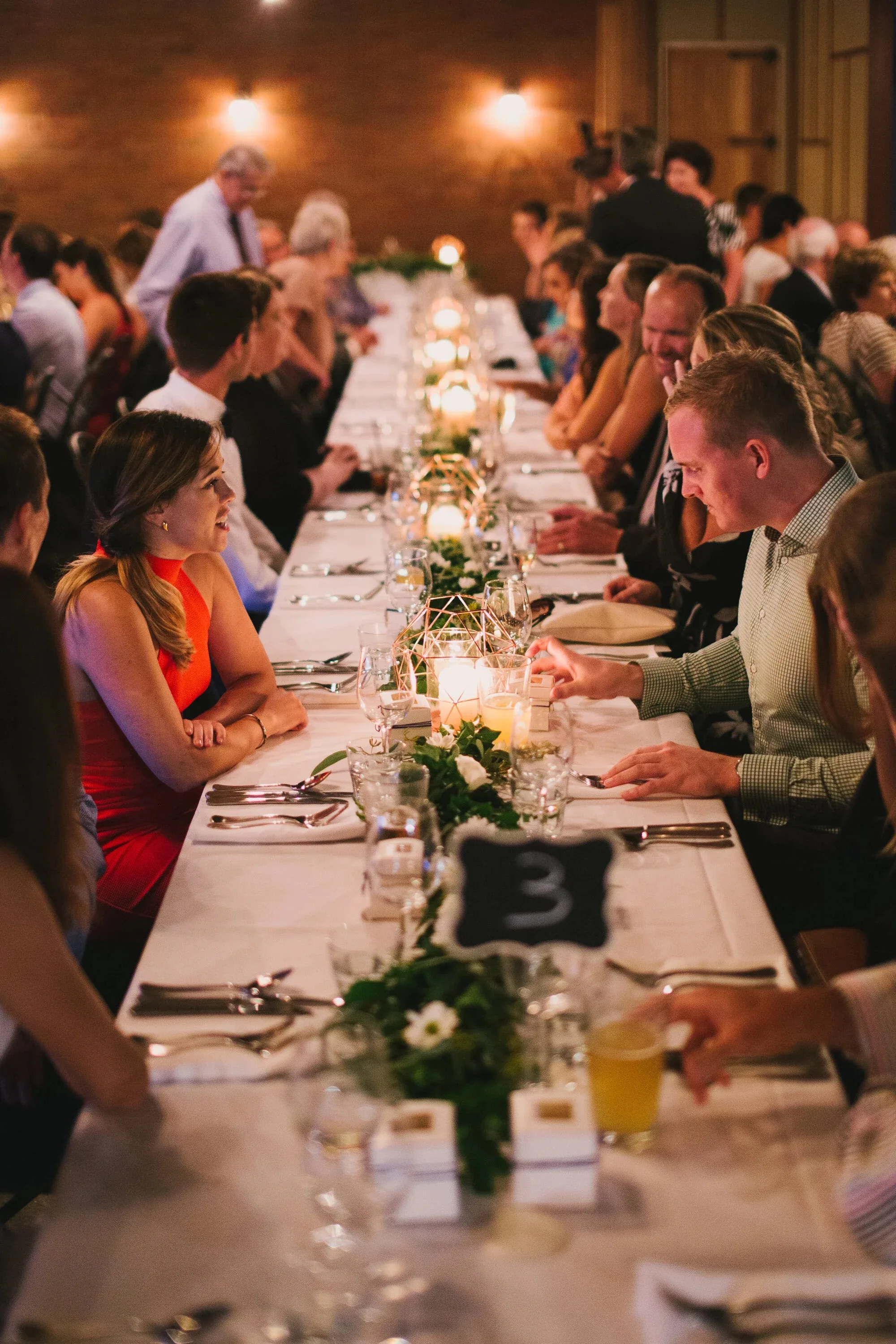 Guests seated and chatting along a candle-lit banquet table during an evening event at Loft West End, Brisbane.
