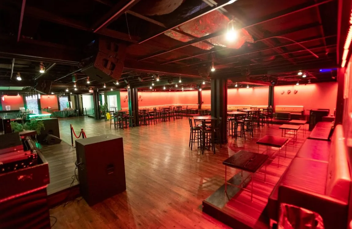 Event space with dance floor and lounge seating under red lighting at La Catrina Lounge, Bethesda