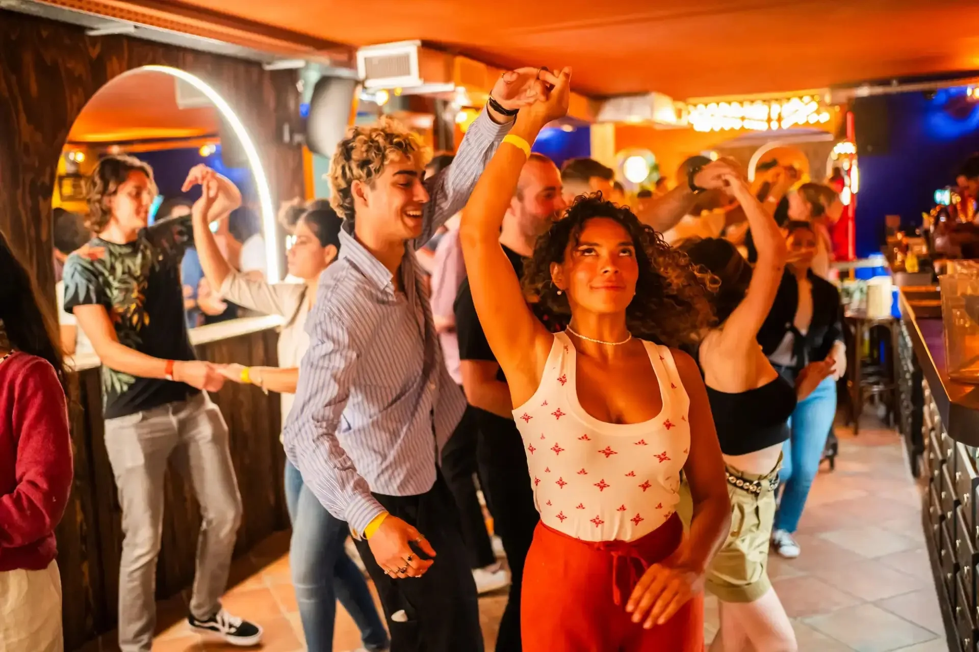 Guests dancing on the floor beside the bar at Au Toucan Fringant, Bordeaux