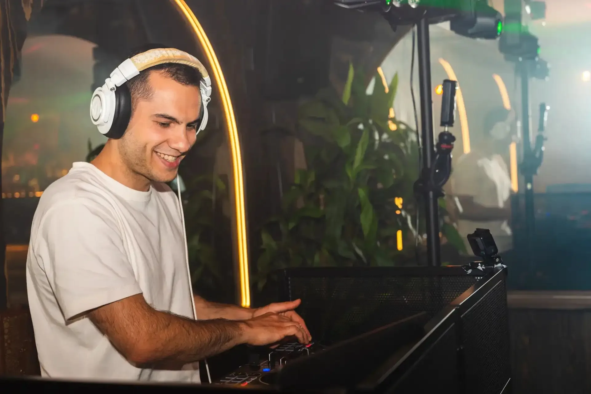 DJ playing at the booth among plants and warm lighting at Au Toucan Fringant, Bordeaux