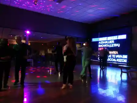 Couples dancing bachata and kizomba on the floor at Sala Ritmo Córdoba with LED display
