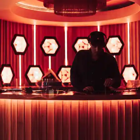 DJ playing music at Cloudland Brisbane Palais bar with red ambient lighting for Latin dance nights — salsa, bachata venue in Brisbane