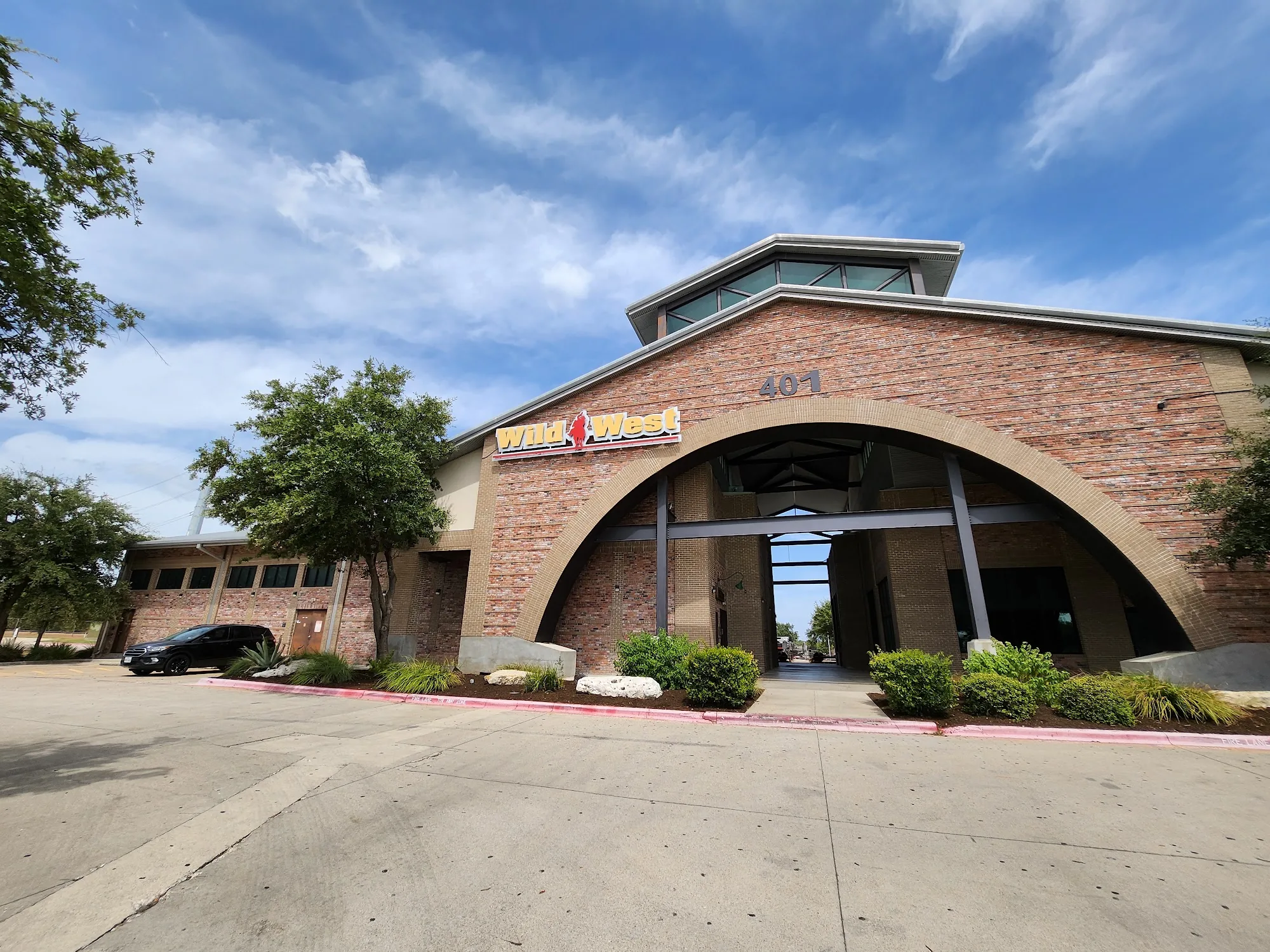 Brick arched entrance with the Wild West sign at Wild West Cedar Park dance hall