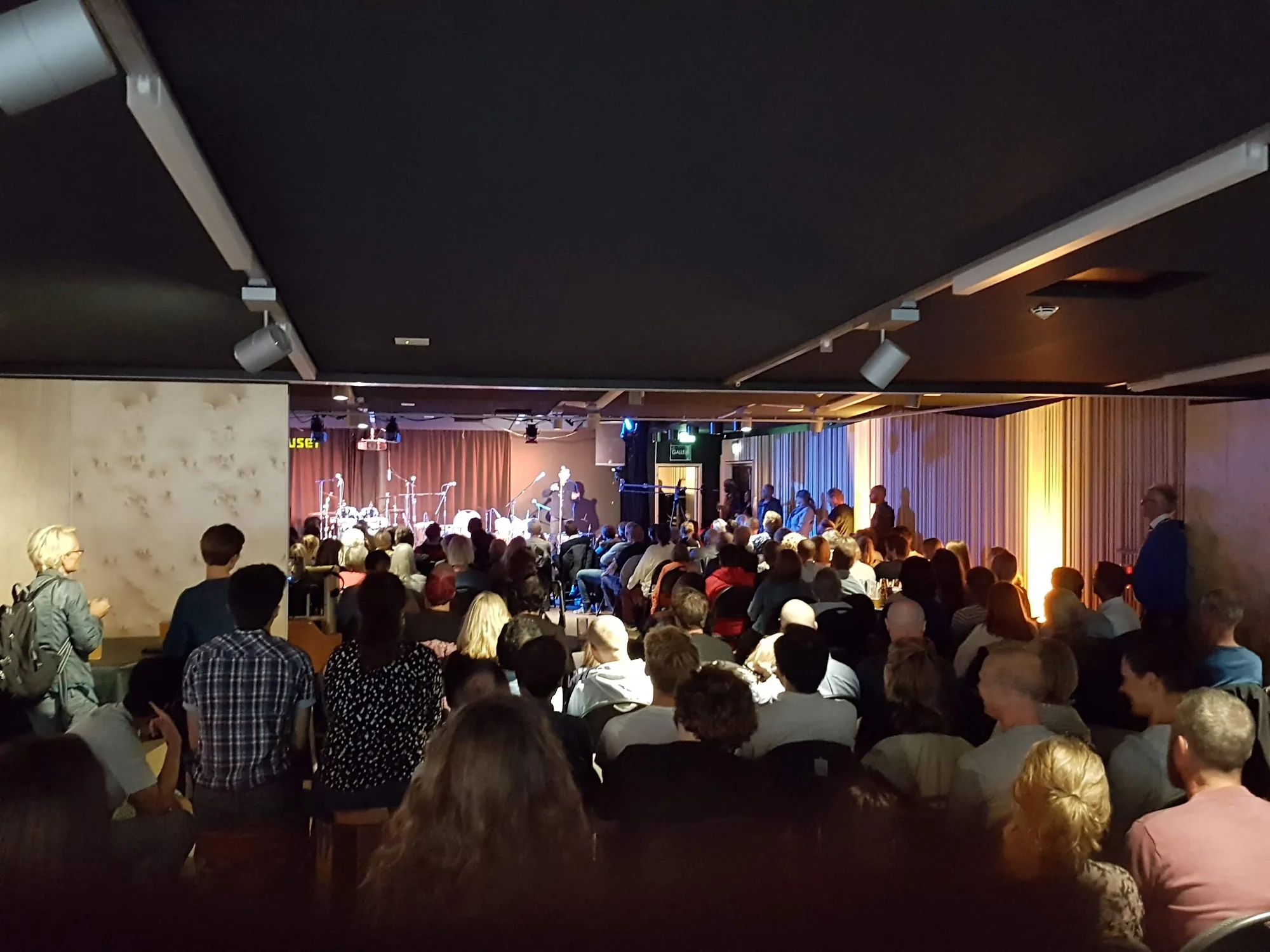 Full house audience watching live concert at Melahuset Oslo with stage and band visible