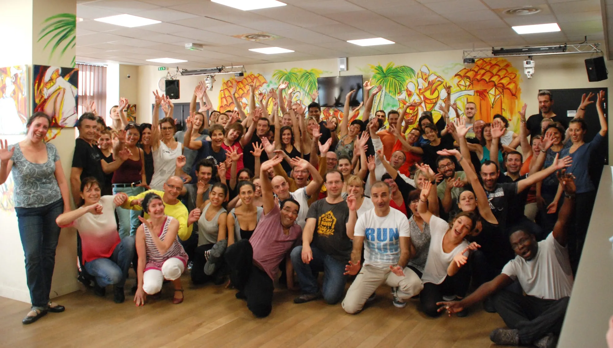 Large group of salsa dancers celebrating in the Salsa Grenoble dance studio