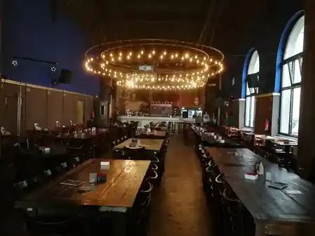 Beyerhaus grand hall interior with circular chandelier and bar at back — bachata venue in Leipzig