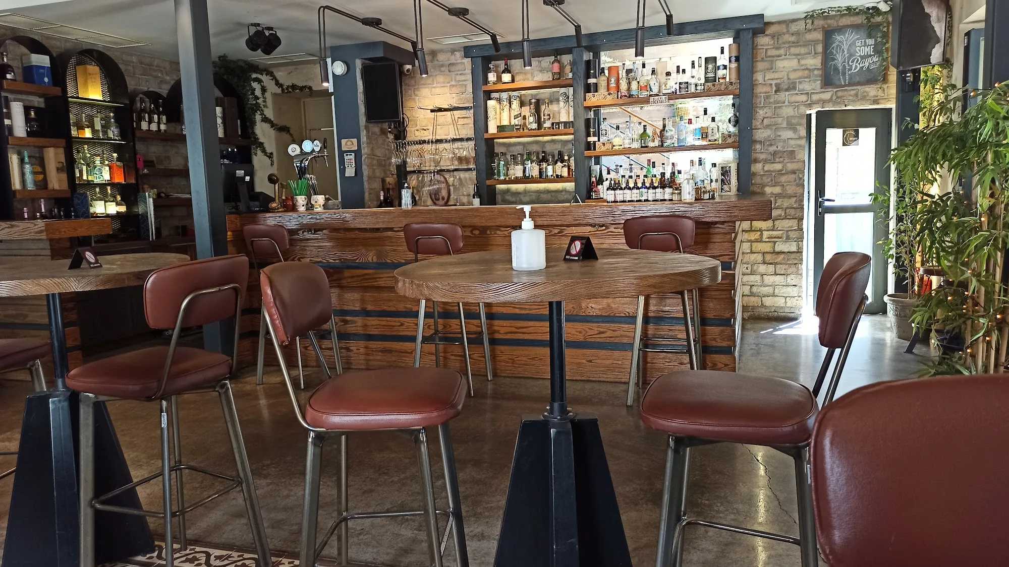 Manor House Athens interior with bar counter wooden stools and exposed brick wall — salsa, bachata, kizomba venue in Athens