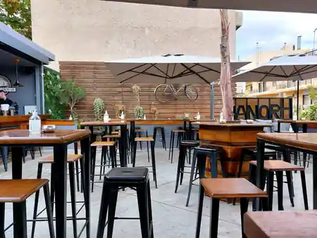 Manor House outdoor terrace in Athens with branded Manor signage visible on the wall — salsa, bachata, kizomba venue in Athens