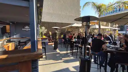 Manor House Athens sunny outdoor patio with guests and Manor House signage in background — salsa, bachata, kizomba venue in Athens