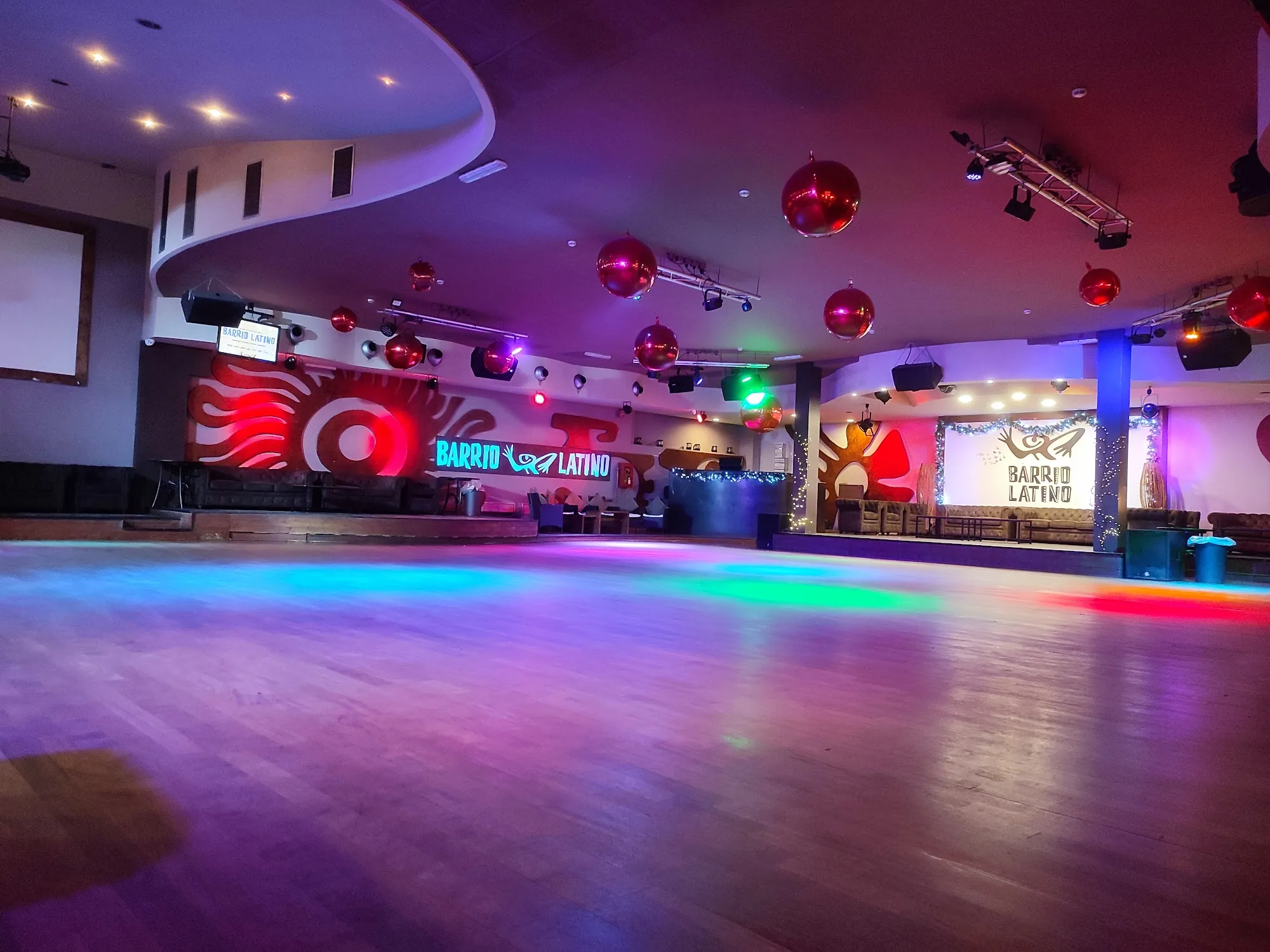 Empty dance floor with disco balls and Barrio Latino branded wall at the Rome club