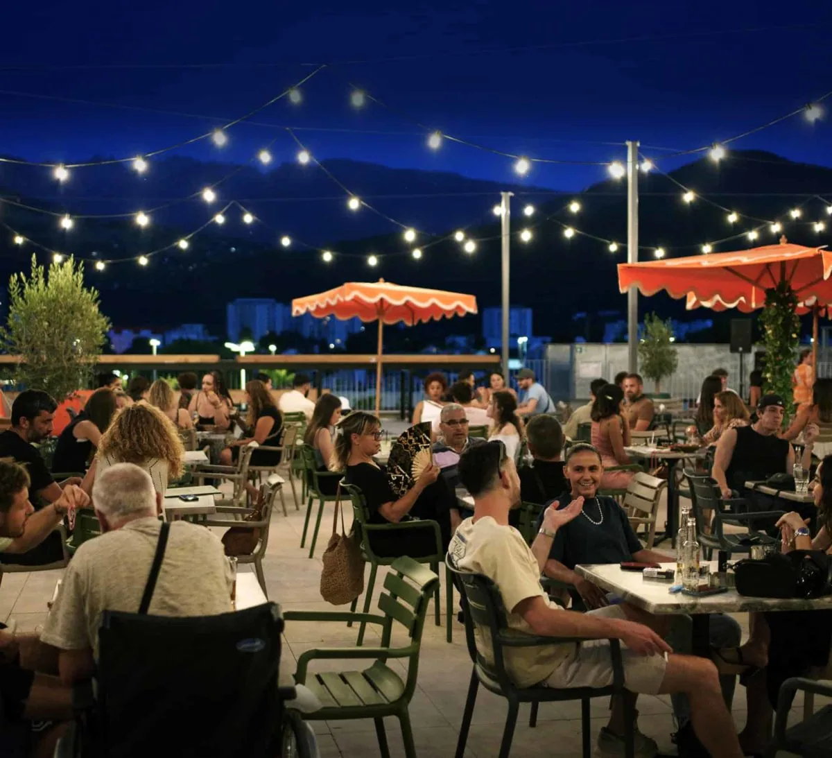 Lively evening rooftop terrace at O'Sullivans Paris with string lights and a packed crowd, the SalsaO'Sulli atmosphere