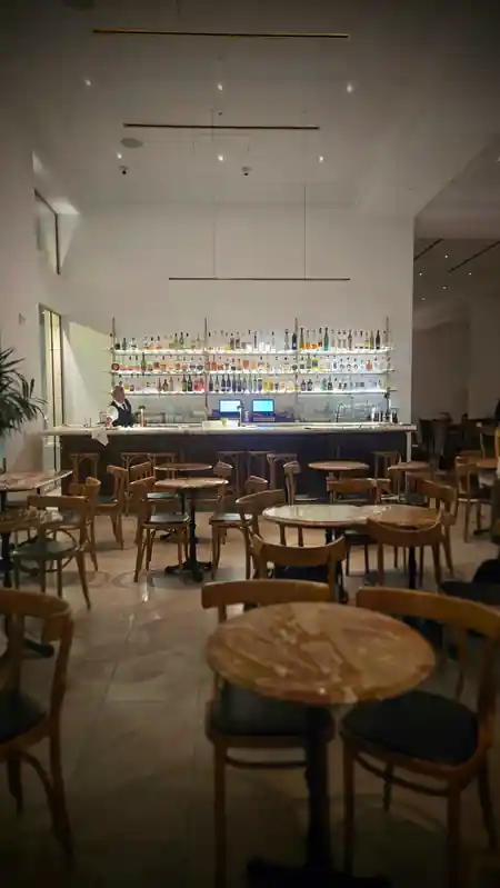 Elegant bar interior at Louie's with backlit spirit bottles, café-style seating and a bartender — salsa, bachata venue in Los Angeles