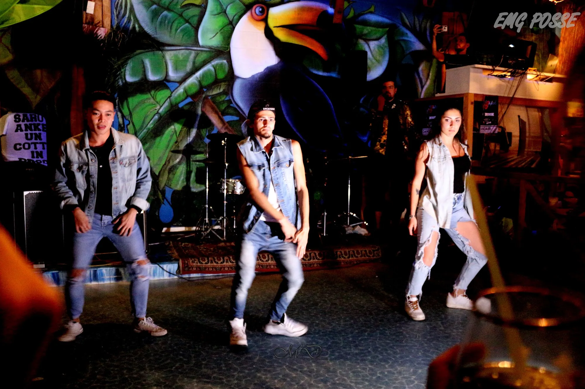 Performers dancing on stage in front of venue murals at Dandarì Disco Pub Italy