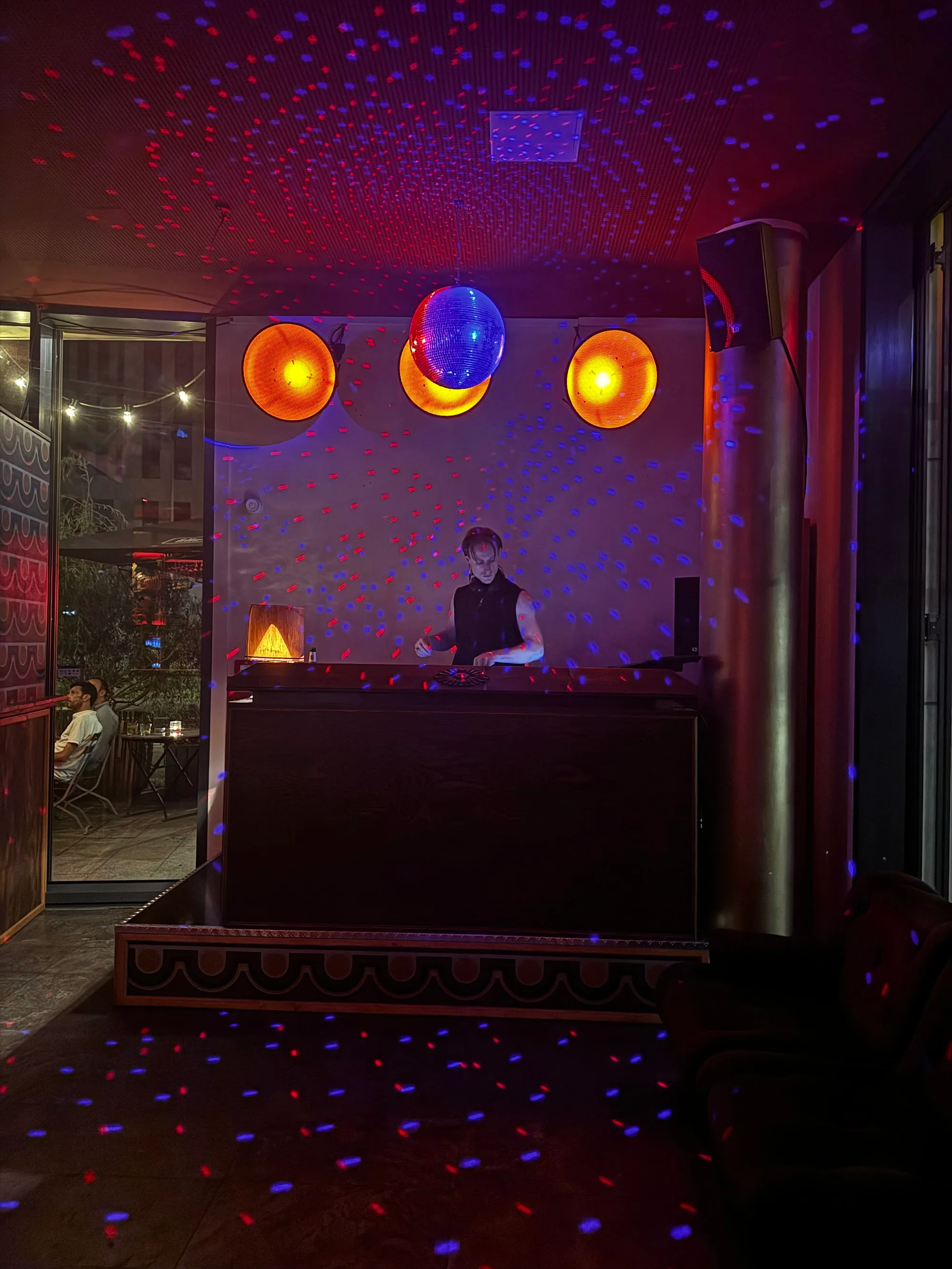 DJ booth with disco ball and party lighting at Wilder als erwartet Bar Berlin