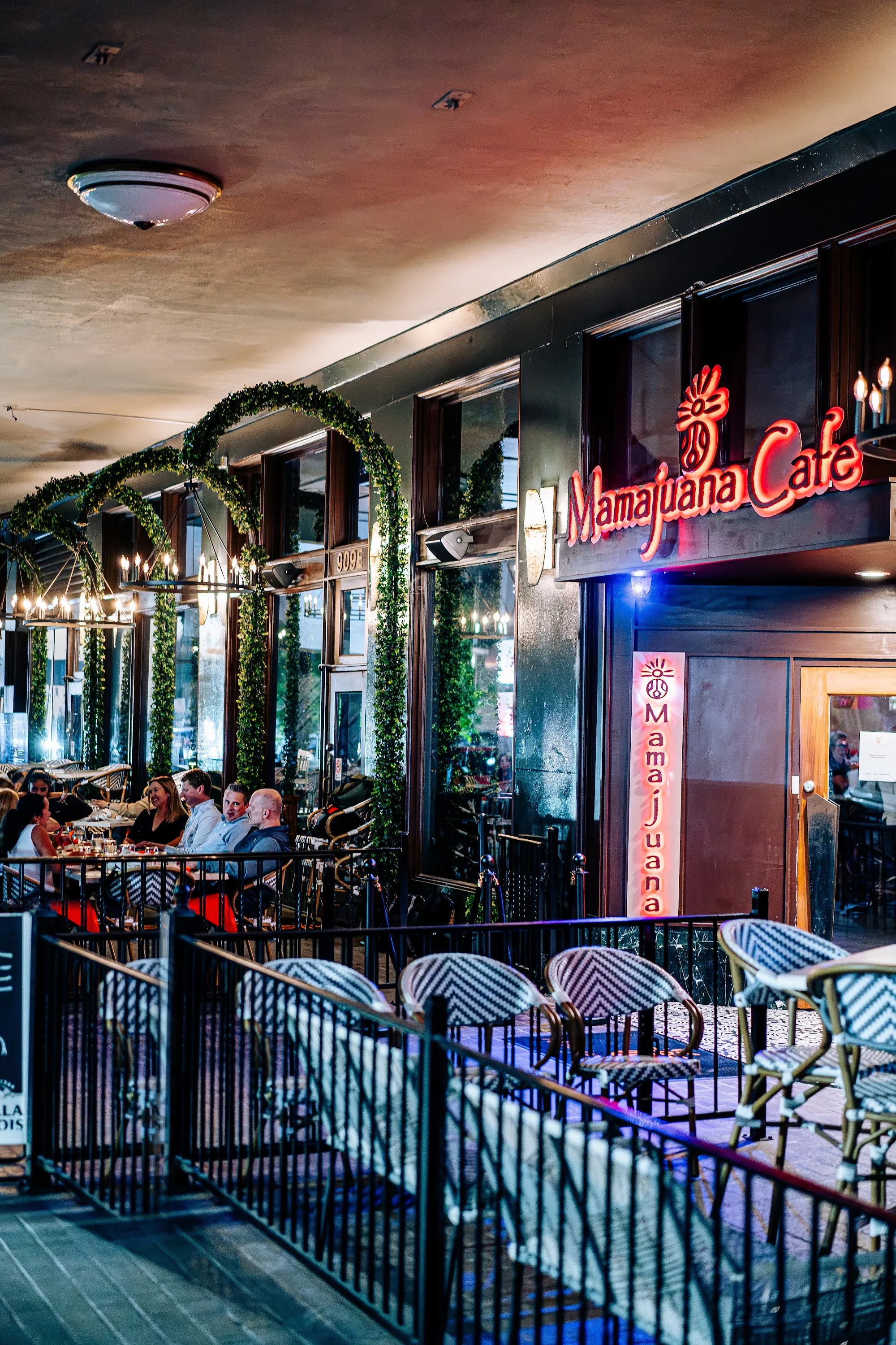 Evening patio and glowing Mamajuana Cafe neon sign, Latin bar in Houston