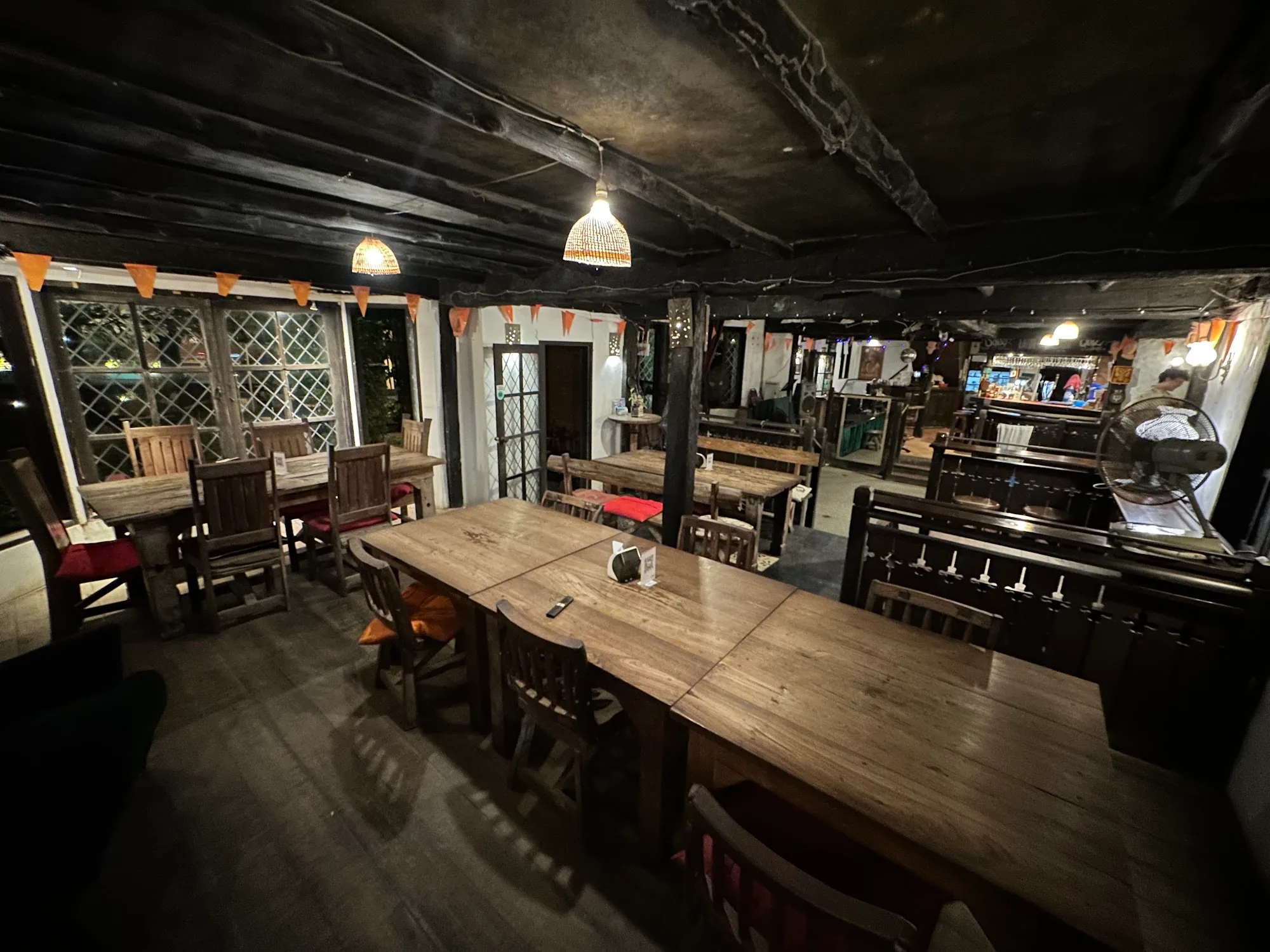 Rustic wooden interior of The Green Man pub with timber beams and pendant lights in Phuket