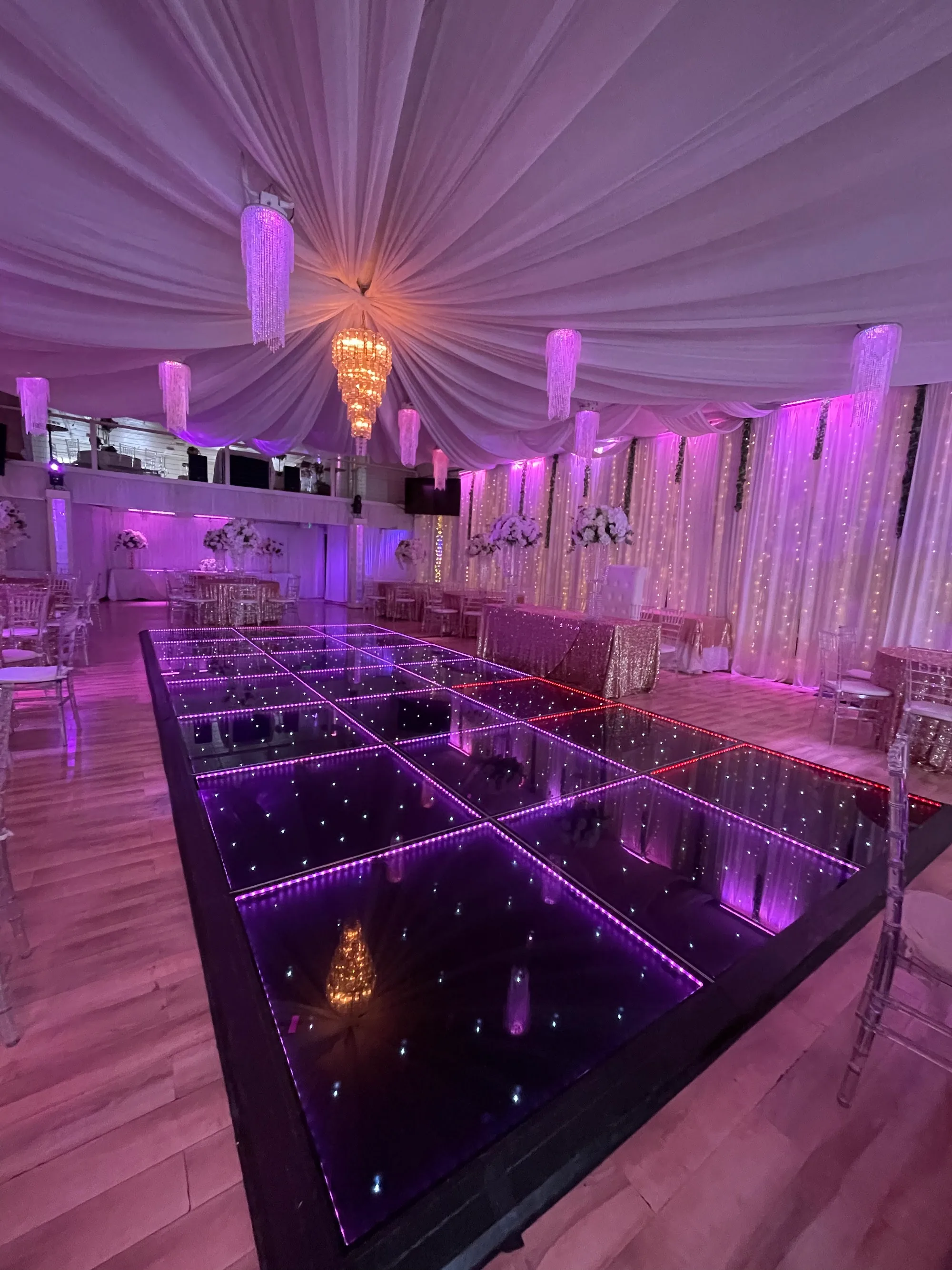 Illusion Hall interior in Chula Vista with LED mirror dance floor, chandeliers and draped ceiling