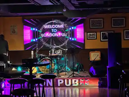 Welcome to London Pub LED screen on stage with live band setup and London Pub signage — salsa venue in Kathmandu
