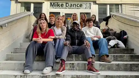 Group of dancers at the Mike Dance Tanzschule entrance with branded signage in Munich — kizomba, bachata venue in Munich