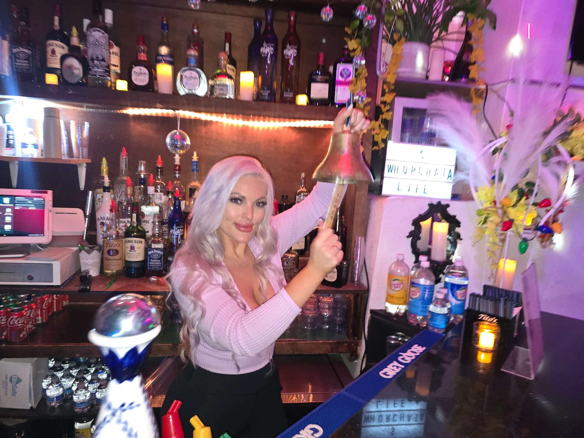 Bartender behind the colorful bottle-lined bar at Cafe Citron in Washington, D.C.