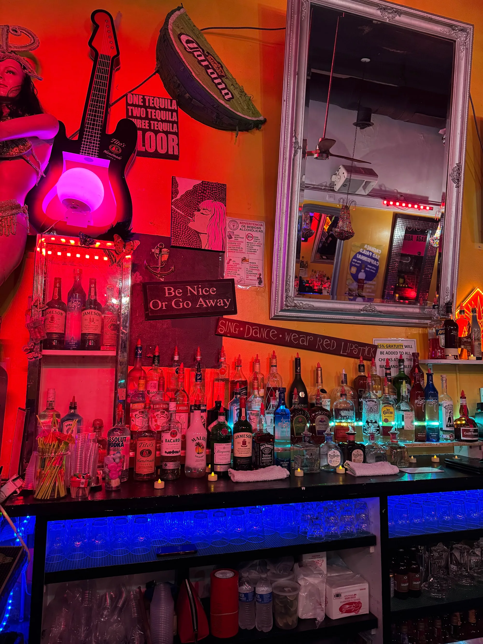Cafe Citron's bar wall with neon Sing Dance Wear Red signage and illuminated bottle shelf in Washington, D.C.