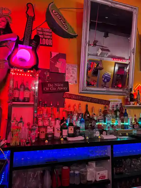 Cafe Citron's bar wall with neon Sing Dance Wear Red signage and illuminated bottle shelf in Washington, D.C. — salsa, bachata venue in Washington, D.C.